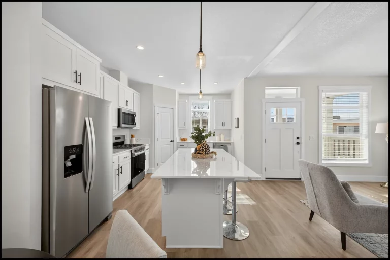 a kitchen with a white island and a silver refrigerator