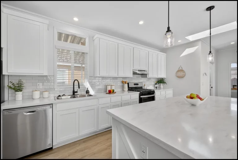 a kitchen with white cabinets and a white countertop