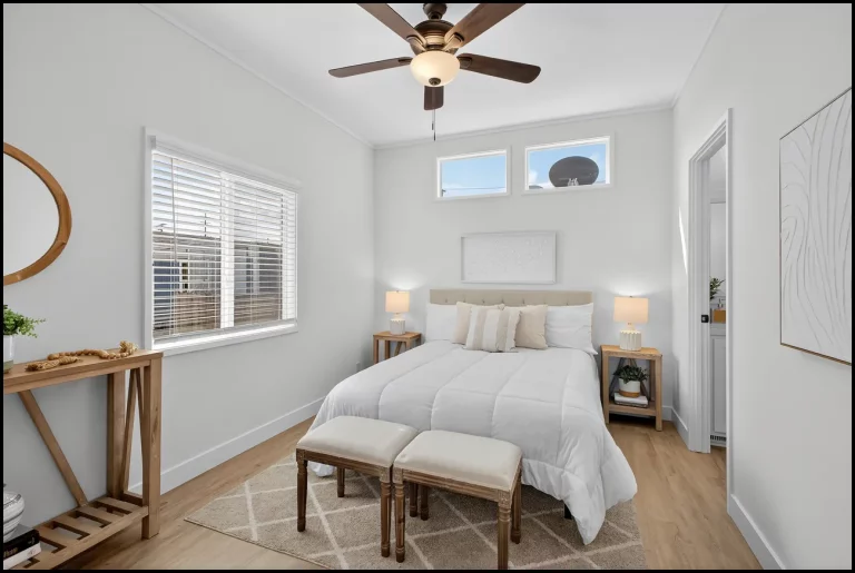 a bedroom with a bed and a ceiling fan