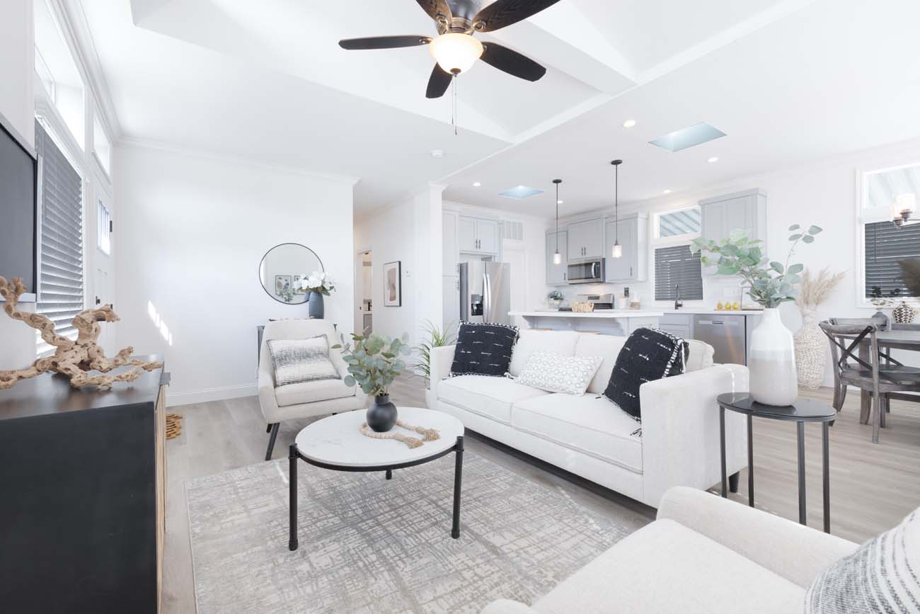 Bright open-concept living room with white sofa and kitchen beyond