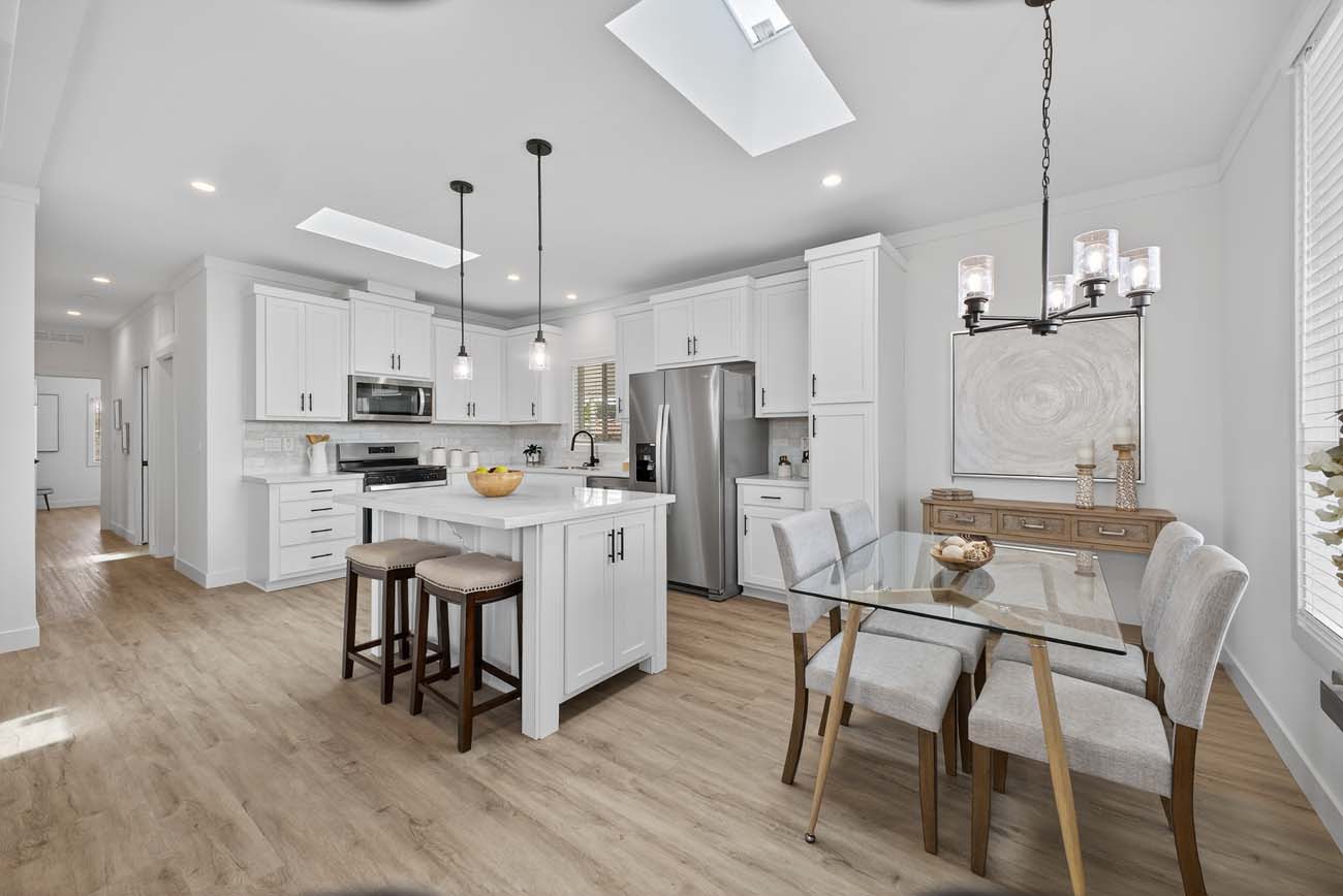White kitchen with island seating and adjacent dining table