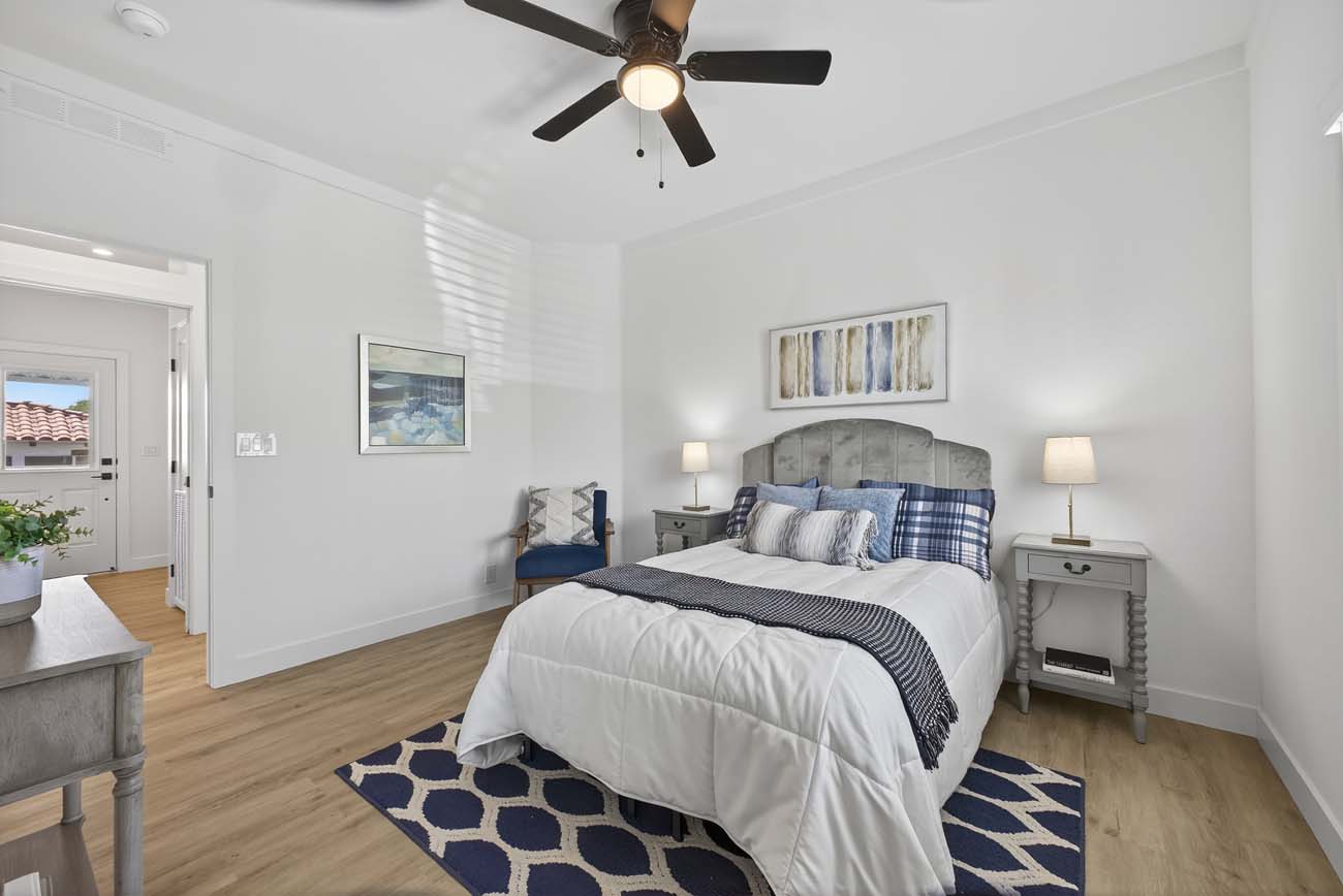 Staged bedroom with plaid bedding and blue geometric area rug