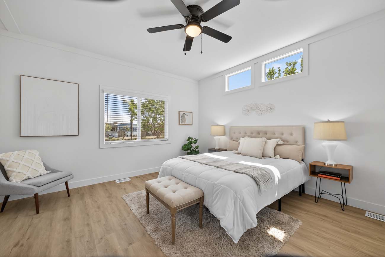 Neutral bedroom with upholstered bed, bench, and clerestory windows