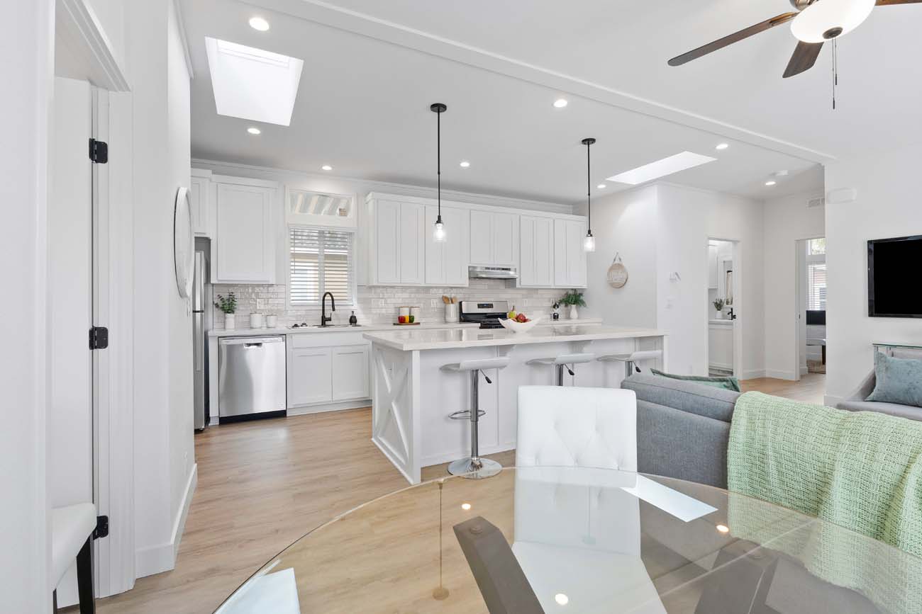 166th Street white kitchen with island, dining table, and skylights