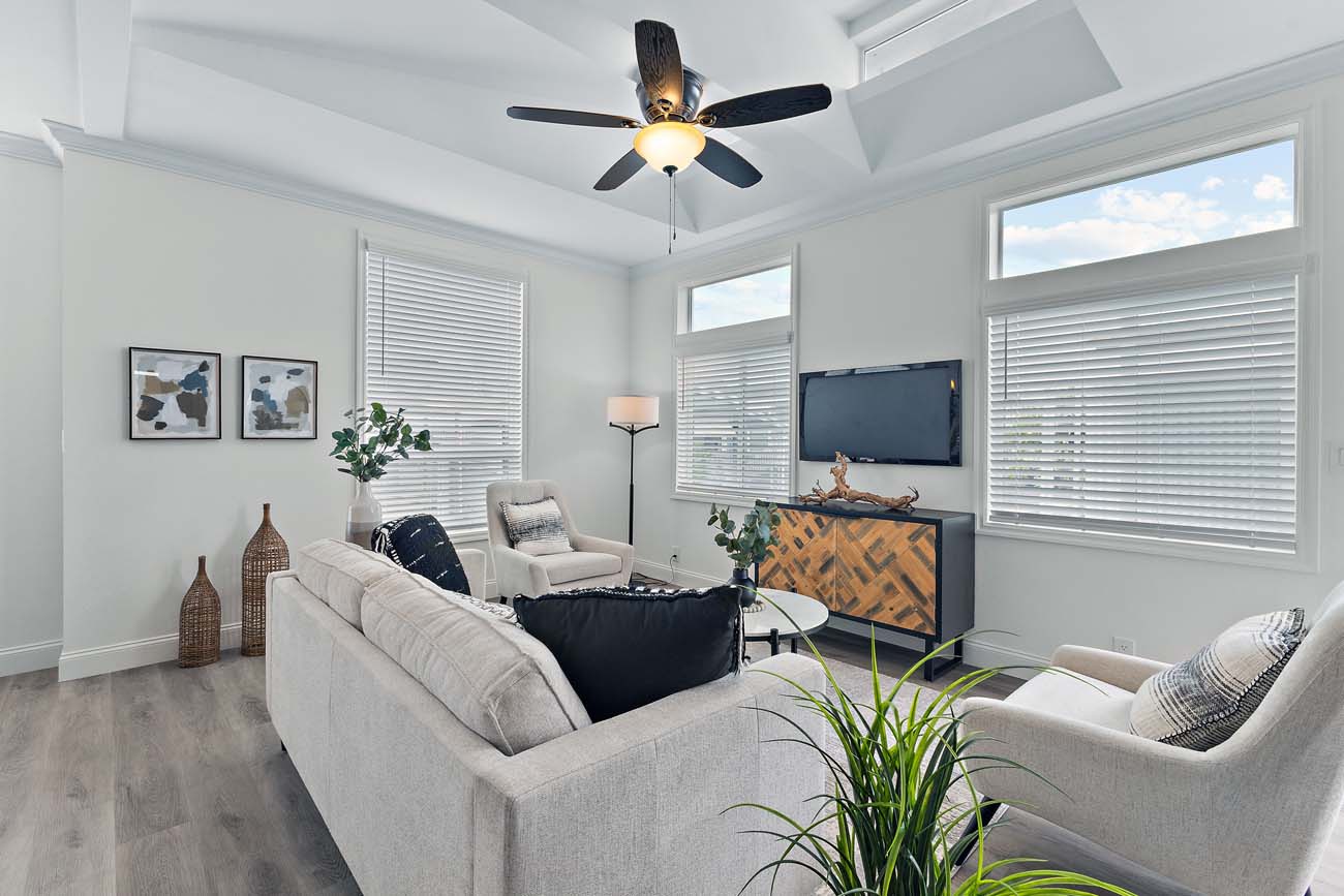 Beach Boulevard living room with large windows, sofas, and wall-mounted television