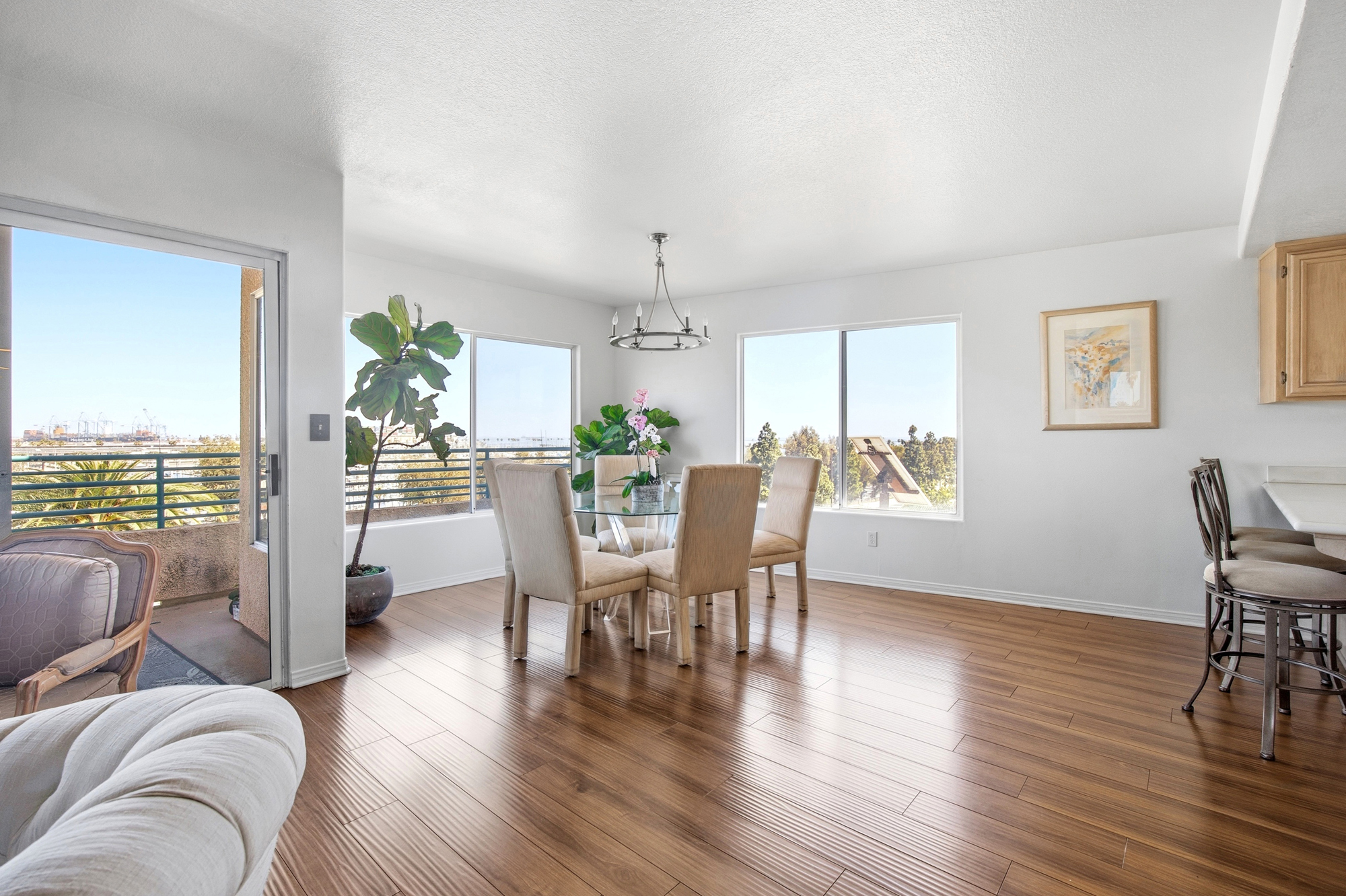 Dining and sitting area with hardwood floors, balcony access, and wide windows