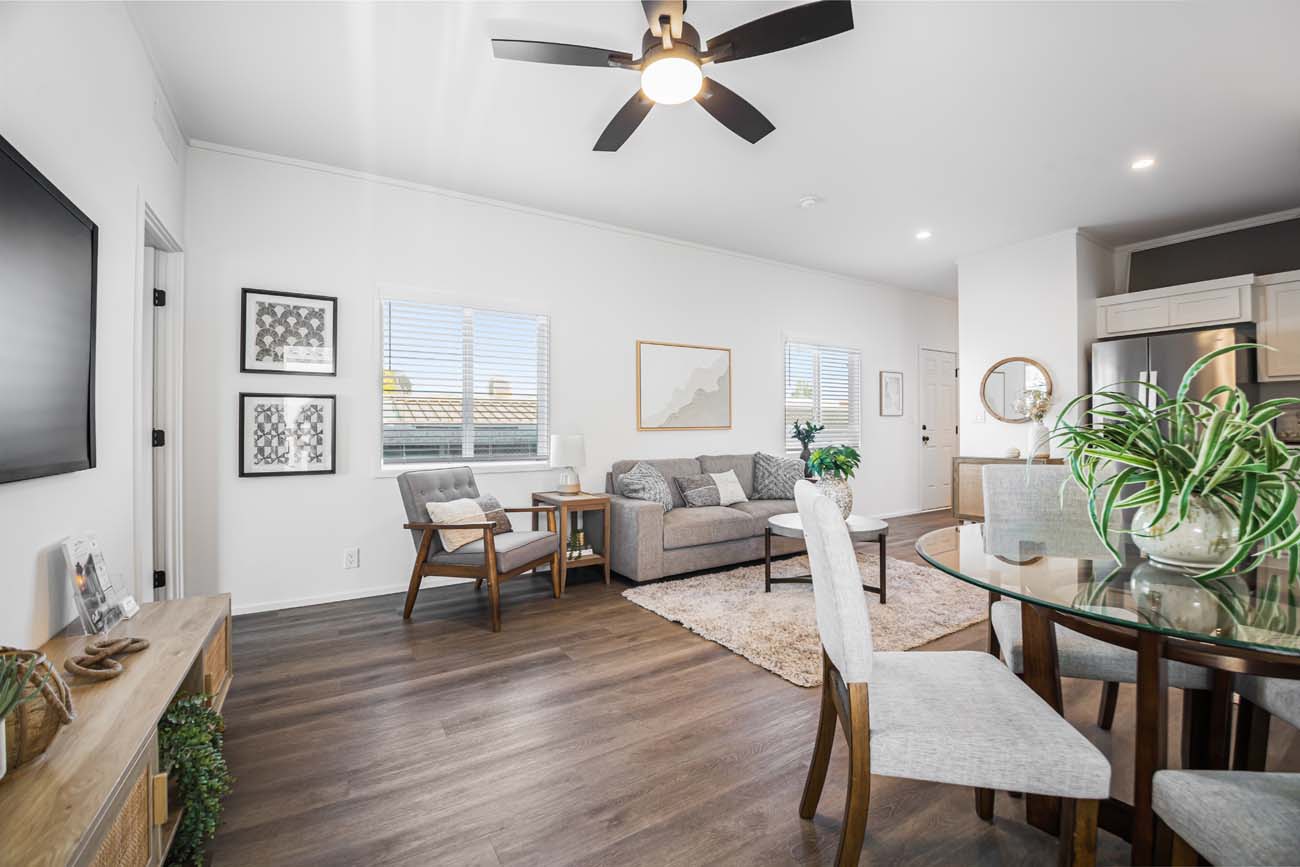 Staged living and dining room with ceiling fan and open kitchen