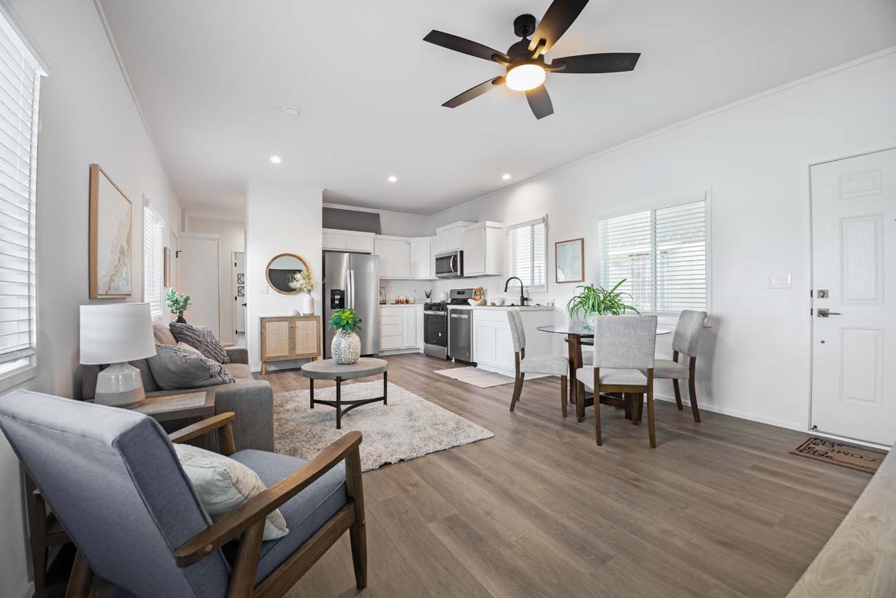 Staged open-concept living, dining, and kitchen area with wood flooring